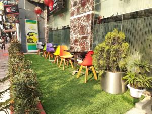 a row of colorful chairs and tables in a restaurant at INNOTEL BATON ROUGE - A Luxury Collection Hotel in Dhaka