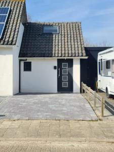 a white garage with a black roof at Calm Down Near The Sea in Vlissingen