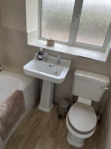 a bathroom with a toilet and a sink and a window at Till Cottage 3 Fenton Hill Farm in Wooler