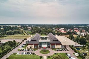 une vue aérienne sur un bâtiment avec un parking dans l'établissement Hotel Arkas, à Prószków