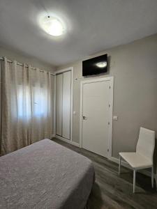 1 dormitorio con 1 cama, 1 silla y TV en Casa Rural A la Vera de Monfrague en Tejeda de Tiétar