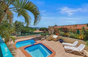 a patio with a swimming pool and some chairs at Shingley Poolside Retreat in Airlie Beach