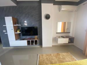 a living room with a tv and a mirror at Best Apartment in Pogradec