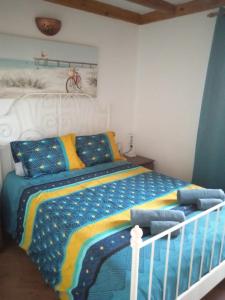 ein Schlafzimmer mit einem Bett mit einer blauen und gelben Bettdecke in der Unterkunft ON THE BEACH in Costa Teguise