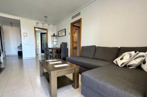 ein Wohnzimmer mit einem Sofa und einem Tisch in der Unterkunft Sunny Patacona Seaview in Valencia