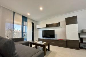 a living room with a couch and a flat screen tv at Sunny Patacona Seaview in Valencia