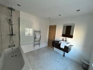 a bathroom with a bath tub and a sink and a bath tub at Westview House by Sasco Apartments in Blackpool