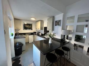 a kitchen with a counter and stools in it at Westview House by Sasco Apartments in Blackpool