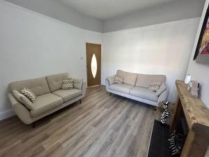 a living room with two couches and a table at Westview House by Sasco Apartments in Blackpool