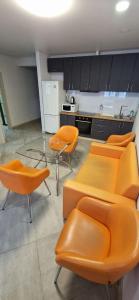 a kitchen with orange chairs and a glass table at Family apartment 2 rooms in Kharkiv