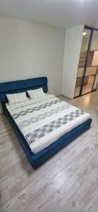 a bed sitting in a room with a wooden floor at Family apartment 2 rooms in Kharkiv