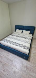a bed with a blue frame in a room at Family apartment 2 rooms in Kharkiv