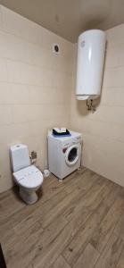 a bathroom with a toilet and a washing machine at Family apartment 2 rooms in Kharkiv