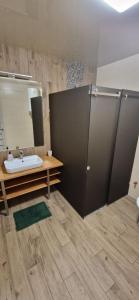 a bathroom with a sink and a shower with a mirror at Family apartment 2 rooms in Kharkiv