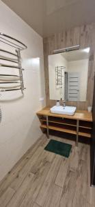 a bathroom with a sink and a mirror at Family apartment 2 rooms in Kharkiv