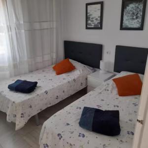 2 łóżka pojedyncze w pokoju z białymi ścianami w obiekcie Pueblo Evita apartment in exclusive holiday complex w mieście Benalmádena +31 zdjęć