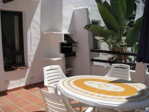 stół i krzesła w pokoju z rośliną w obiekcie Pueblo Evita apartment in exclusive holiday complex w mieście Benalmádena