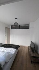 a white bedroom with a bed and a table at Zen Home - appartement jusqu'à 4 voyageurs in Nantua