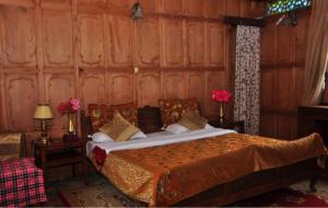 Alif Laila Group of Houseboats, Srinagar في سريناغار: غرفة نوم بسرير في جدار خشبي