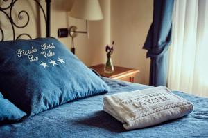 a pillow on a bed with a blue blanket at Piccolo Hotel La Valle in Pienza