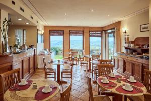 un ristorante con tavoli, sedie e finestre di Piccolo Hotel La Valle a Pienza
