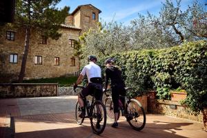 a man and woman riding bikes down a sidewalk at Piccolo Hotel La Valle in Pienza