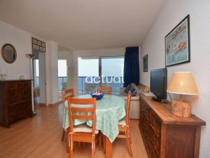 a dining room with a table and chairs and a television at President B-14 in Platja d'Aro