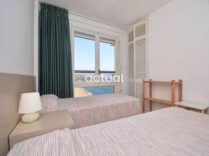 a hotel room with two beds and a window at President B-14 in Platja d'Aro