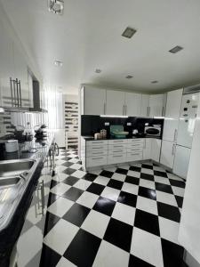 アルマダにあるCocas House II - Almadaの黒と白のチェッカーフロアのキッチン