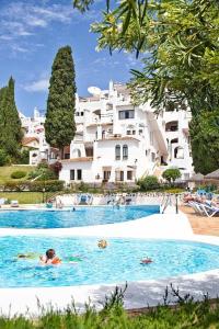 grupa ludzi pływających w dużym basenie w obiekcie Pueblo Evita apartment in exclusive holiday complex w mieście Benalmádena