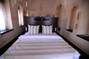 1 dormitorio grande con 2 camas con sábanas blancas en Shmayaa Hotel, en Midyat