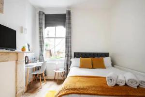 a bedroom with a bed and a desk and a window at Alross Room with Breakfast in London