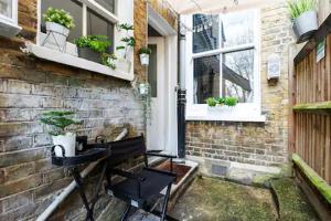 a brick house with a bench and windows at Alross Room with Breakfast in London