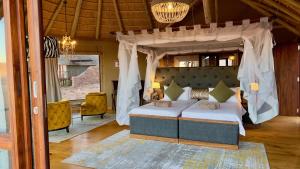 1 dormitorio con 1 cama con dosel en Namib Outpost, en Sesriem