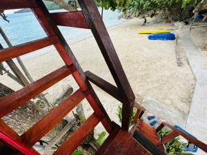 a view of a beach from a wooden window at Dragon Pearl Beach Resort in Kota Belud