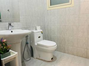 a bathroom with a white toilet and a sink at Luxury private Studio apartment close to Airport in Abu Dhabi