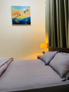 a bedroom with a bed and a painting on the wall at Luxury private Studio apartment close to Airport in Abu Dhabi
