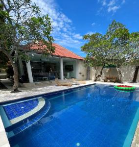 a swimming pool in front of a house at Villa Neshama in Canggu