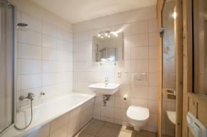 a bathroom with a tub and a sink and a toilet at Ferienwohnung Strandnest Sierksdorf in Sierksdorf