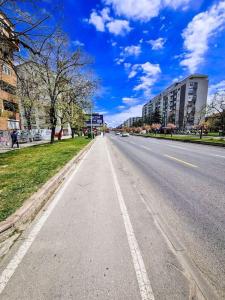 an empty street in a city with tall buildings at The Modern Lodge in Skopje