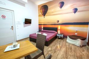 a bedroom with a bed and a table and hot air balloons at B&B al volo2 in Foggia