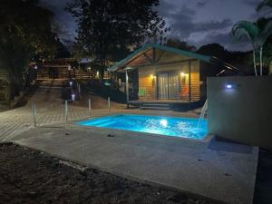 a swimming pool in front of a house at night at Casa Cooper in Carrillo