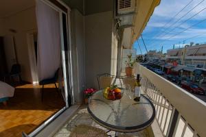 a balcony with a table and a bottle of wine at Esperidon Luxury Apartment Glyfada in Athens