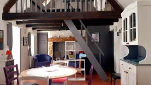 ein Zimmer mit einem Tisch, Stühlen und einer Treppe in der Unterkunft La Beuvrequentoise 1 in Beuvrequen