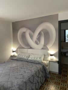 - une chambre dotée d'un lit avec une grande sculpture sur le mur dans l'établissement Marta House 2, à Trapani