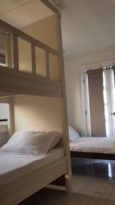 two bunk beds in a room with a window at Melvince Lodging House in Vigan