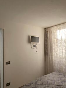 - une chambre avec une télévision murale et un lit dans l'établissement Marta House 2, à Trapani