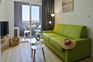 a living room with a green couch and a table at Résidence Easy Lodge in Ajaccio