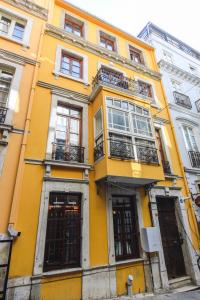 a yellow building with windows and balconies on a street at 9 Pera in Istanbul