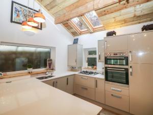 een keuken met witte werkbladen en houten plafonds bij Compton Lodge in Buxton